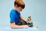 Boy playing with Minecraft LEGO.