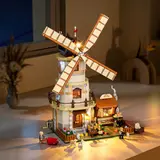 Lit windmill on a window sill at night.
