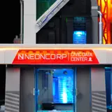 Close-up of lit 'NEONCORP' entrance sign.