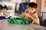 Child playing with Lego Technic Porsche REXY.